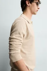 Sweater polo de punto de mezcla de algodón en color negro, con cuello solapa, abertura frontal y mangas largas con acabado en rib.