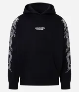 Hoodie negro de algodón con felpa interna, capucha y bolsillo canguro. Presenta diseño estampado de dragón oriental en ambas mangas y texto en el pecho.