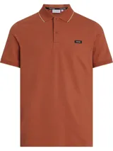 Chomba color ladrillo de piqué de algodón orgánico, corte slim, cuello polo con ribete color crema, tapeta de dos botones, mangas cortas con puños de punto y logo de Calvin Klein en el pecho.