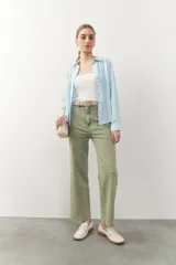 Camisa de manga larga blanca con alforzas y detalles de vainica en el frente, cuello camisero y cierre frontal de botones.