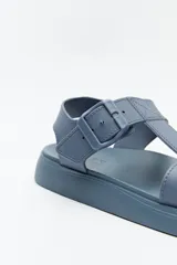 Sandalia baja negra con tiras anchas y hebilla lateral.