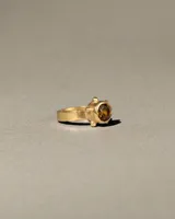 Anillo de banda chata de plata 925 con baño de oro 24k, protagonizado por una piedra citrino facetada central de 8mm, enmarcada por una secuencia de esferas.
