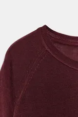 Jersey de punto fino con diseño de rayas horizontales en azul marino y blanco, cuello redondo y manga larga con corte raglán.