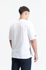 Remera blanca de algodón, corte oversize, manga corta y cuello redondo.