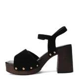 Sandalias negras Miss Carol modelo Torino, con plataforma y taco alto de madera, tira ancha en el empeine con hebilla dorada y tachas decorativas, y tira con hebilla en el tobillo.