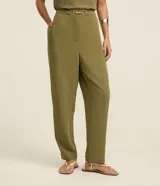 Pantalón negro de corte zanahoria, con cintura elástica, adorno metalizado en la cintura y bolsillos laterales.