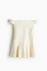 Top de punto tupido color marfil, con diseño de hombros descubiertos y corte acampanado con peplum en la parte inferior.