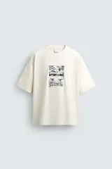 Camiseta de corte relajado color crudo, con cuello redondo y manga corta. Presenta un estampado gráfico en el frente con motivos de palmeras y paisajes en color negro.