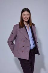 Chaqueta de paño con doble abotonadura, botones de cuero y cuello de piel sintética. Presenta un diseño de largo a la cadera con bolsillos verticales delanteros y forro interior.