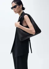 Chaleco tipo blazer sin mangas, de corte oversize y tejido de lino. Presenta cuello con solapas de muesca, bolsillos laterales de ribete y diseño abierto sin cierre.