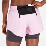Short deportivo New Balance Impact Run AT 3 Inch 2-in-1 para mujer. Diseño 2 en 1 con short exterior rosa y calza interior gris. Confeccionado en poliéster ligero con tecnología NB DRY.
