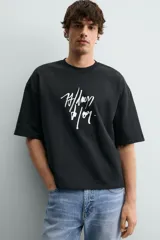 Sudadera de corte relajado confeccionada en algodón, con cuello redondo, manga corta y acabado en rib. Presenta un estampado gráfico a contraste en la parte frontal.