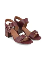 Sandalias de taco ancho simil madera, color bordó con textura reptil, tira frontal con hebilla dorada y tira ajustable en el talón con hebilla metálica grande.