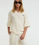 Bermuda masculina color beige claro, con textura, cintura elástica ajustable con cordón y bolsillos laterales.