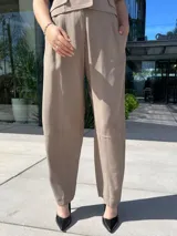 Pantalón de vestir color beige, de corte recto y tiro alto, con bolsillos laterales y cierre frontal.