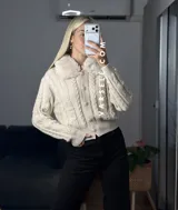 Saco tejido de punto con diseño de ochos, cuello con detalle de piel sintética, cierre frontal con botones al tono y mangas largas.