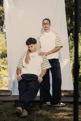 Remera unisex de jersey color blanco con mangas raglán a rayas horizontales en tonos verde oliva y blanco. Presenta un pequeño bordado en el pecho.