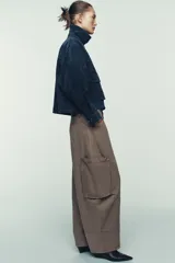 Cazadora estilo bomber confeccionada en piel, con cuello solapa, manga larga y cierre frontal con cremallera oculta y botones a presión. Presenta bolsillos delanteros de plastrón con solapa y botón a presión.