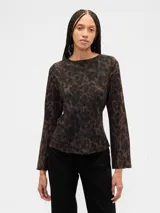 Remera de manga larga con cuello bote y corte recto, confeccionada en tela con estampado animal print en tonos oscuros.