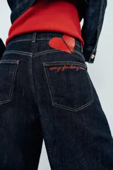 Jeans de tiro alto confeccionados en denim azul oscuro, con diseño barrel de pernera holgada que se estrecha hacia los tobillos. Cuenta con cinco bolsillos, trabillas para cinto y cierre frontal con cremallera y botón.
