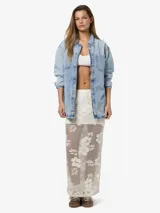 Falda larga color crudo con diseño de encaje floral, corte recto y cintura elástica.