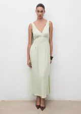 Vestido largo color verde menta, con escote en pico, tirantes anchos y diseño evasé. Presenta detalles de encaje en la zona del torso y cierre de cremallera en la parte posterior.