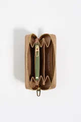 Billetera compacta color tostado con cierre de cremallera metálica dorada y logo de la marca en relieve dorado.