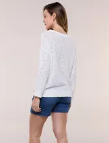 Buzo liviano de algodón con tejido de punto abierto y semi holgado, color beige, con escote bote, mangas largas de hombros caídos y costuras expuestas.