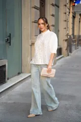 Jean de tiro alto con corte recto y silueta amplia, confeccionado en denim de lavado claro. Presenta cierre frontal con botón y bolsillos laterales y traseros.