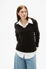 Sweater de tejido de punto color negro, con cuello en V y diseño holgado de manga larga.