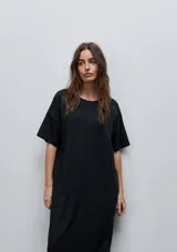Vestido midi negro de algodón con calce relajado, silueta recta, cuello redondo, mangas cortas amplias y tajos laterales.
