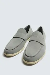 Mocasín casual de hombre, color marrón oscuro (bordó), fabricado en piel con acabado serraje (gamuza). Presenta un detalle de antifaz en el empeine y suela a contraste de color beige claro.