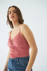 Musculosa de tejido acanalado color verde, con escote en V y detalle de nudo frontal. Presenta breteles finos ajustables.