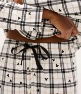 Pijama estilo americano compuesto por camisa de manga larga con botones y pantalón largo. Presenta un estampado a cuadros con pequeños iconos de Mickey Mouse. Confeccionado en tejido suave y ligero.