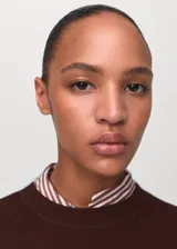 Jersey de punto fino con diseño combinado en bloques de color marrón y celeste. Presenta cuello redondo, corte recto y mangas largas.