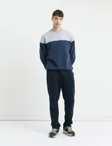 Pantalón jogging de corte recto, confeccionado en tejido circular con cintura elástica y cordón ajustable al tono. Presenta bolsillos laterales tipo parche.