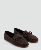 Mocasines de gamuza color marrón oscuro, con detalle de lazo en el empeine y suela plana.