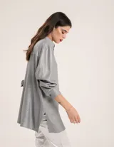Camisa oversized con terminación metalizada color gris plomo. Tiene botones a tono en el delantero, largo por debajo de la cadera y tajos a los costados.