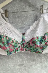 Soutien reductor con aro, confeccionado en lycra estampada con flores y puntilla negra. Breteles regulables.