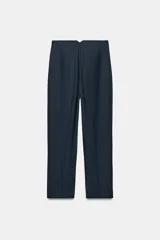 Pantalón de tiro alto con costuras frontales marcadas, bolsillos laterales de vivo y cierre frontal con cremallera, botón y gancho metálico.