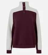 Buzo deportivo de corte oversized, con diseño bicolor en bordó y blanco. Presenta cuello alto con cierre de botones a presión, mangas largas con textura acanalada y puños elásticos.