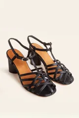 Sandalia de cuero negro con tiras cruzadas en el empeine, diseño en T con tira ajustable al tobillo y taco cuadrado.