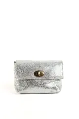 Cartera tipo mini bag de cuero con acabado metalizado plateado y efecto craquelado. Presenta una solapa frontal con cierre giratorio metálico en tono bronce envejecido. Incluye doble correa para usar al hombro o como bandolera y cuenta con un bolsillo interior.