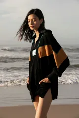 Hoodie de tela de toalla color azul, con cuello alto y cierre frontal de cremallera amarilla. Presenta bloques de color rojo en los hombros y detalles de ribetes amarillos. Tiene un bolsillo tipo canguro y un parche decorativo en el pecho.