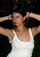 Par de aros colgantes con forma de flor roja de acrílico y aro dorado.