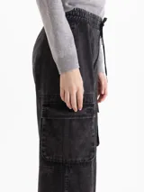 Pantalón cargo de silueta amplia y corte recto, confeccionado en algodón con efecto lavado. Presenta cintura elastizada con cordón de ajuste, bolsillos laterales tipo cargo y bolsillos frontales.