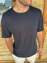 Remera de corte oversize color negro, confeccionada en tejido de punto con textura acanalada horizontal. Presenta cuello redondo y mangas cortas.