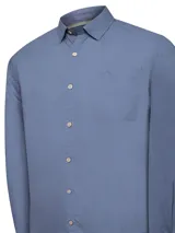 Camisa de manga larga de algodón orgánico color azul, con botones de madera, bolsillo frontal en el pecho con logo bordado y ajuste de mangas.