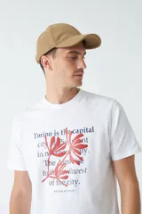 Remera blanca de algodón con estampado de texto en azul y rojo.