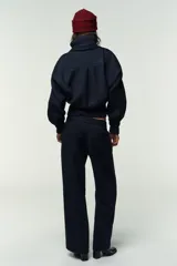 Pantalón de tiro alto con pernera recta, bolsillos delanteros y bolsillos de plastrón en la espalda. Presenta detalle de costura marcada en el frente y cierre con cremallera, botón interior y gancho.